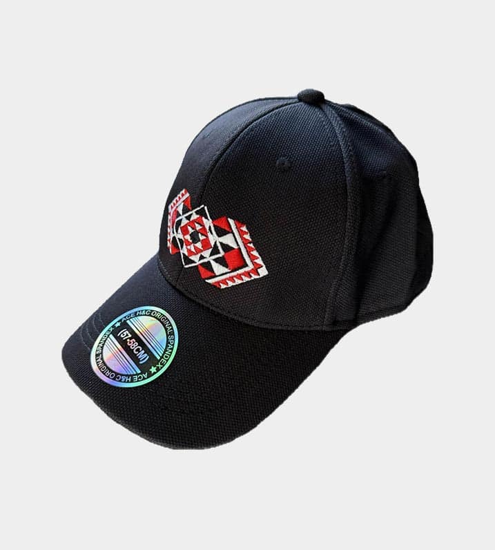 Black Māori pōtae cap showcasing Kapa Haka Makers' distinctive red Tāniko design embroidered onto the front.